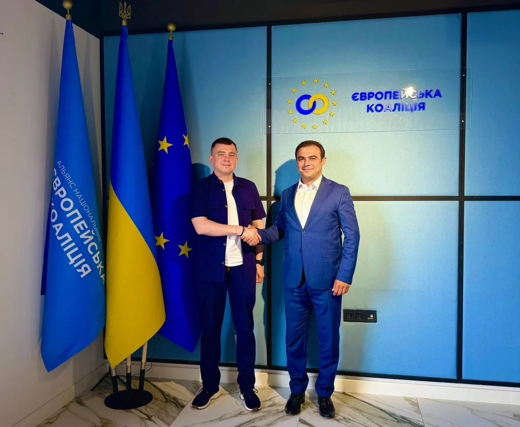 Рукостискання під час зустрічі в офісі «Європейської Коаліції» на тлі прапорів України та ЄС